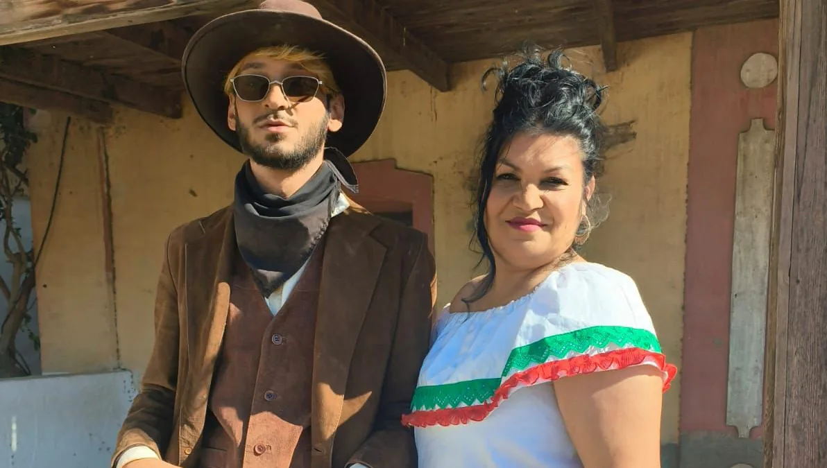 Fotograma de «Los Jerraos»: un hombre vestido de pistolero del Oeste y una mujer con traje mexicano posan ante un decorado.