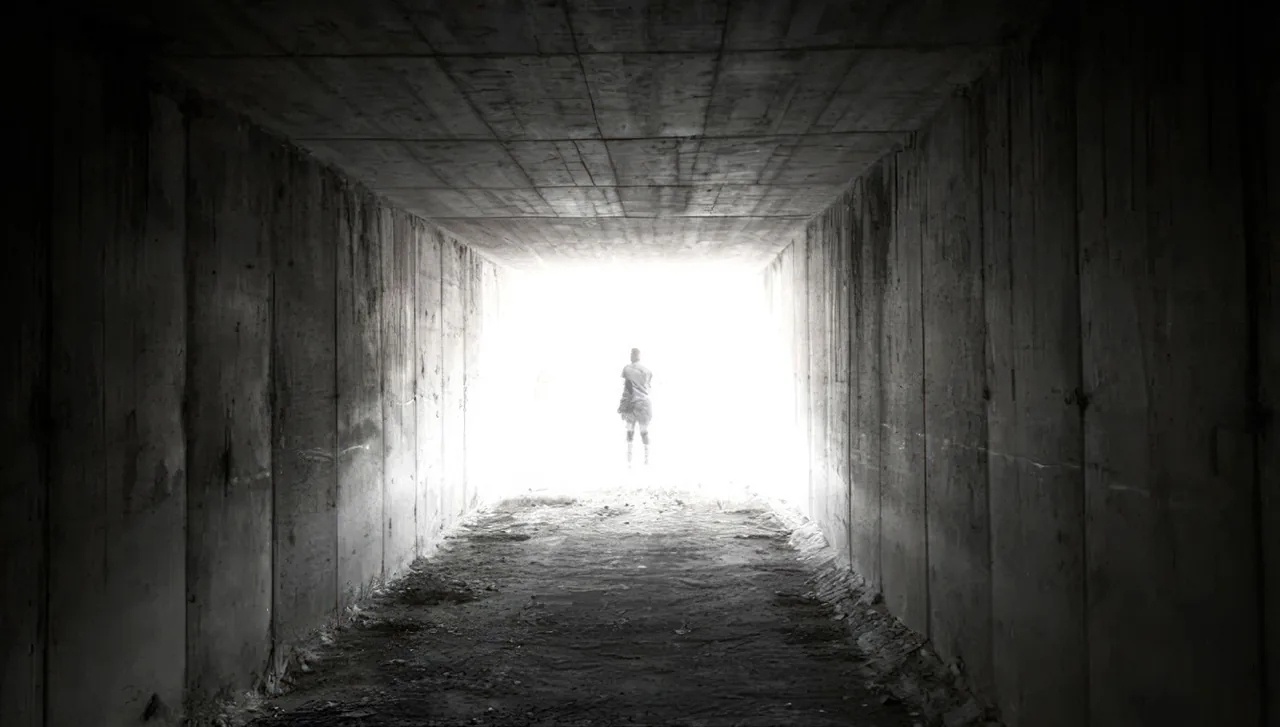 Fotograma de «Teleport»: una silueta al fondo de un túnel oscuro, a contraluz.